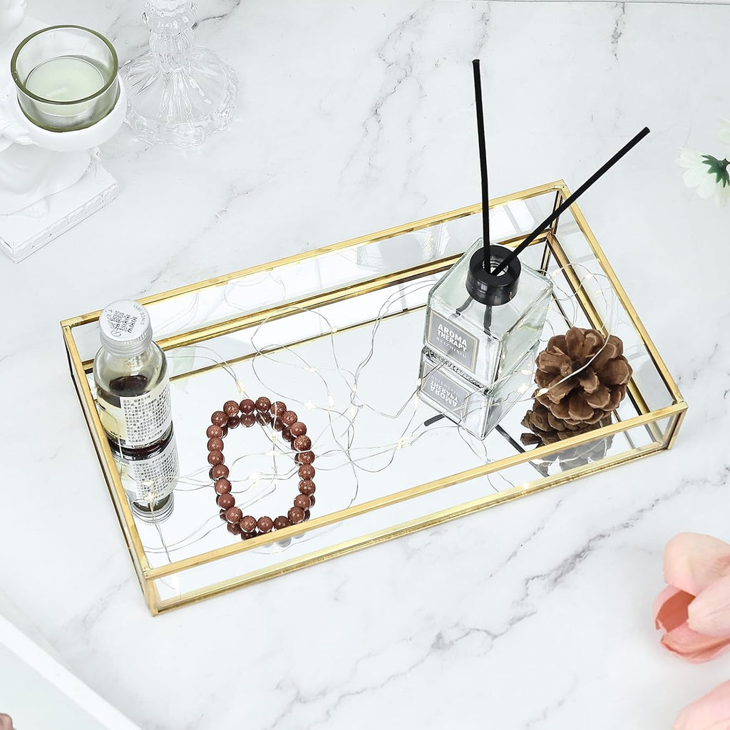 Mirrored vanity tray arranged with perfume and jewelry; contents not included