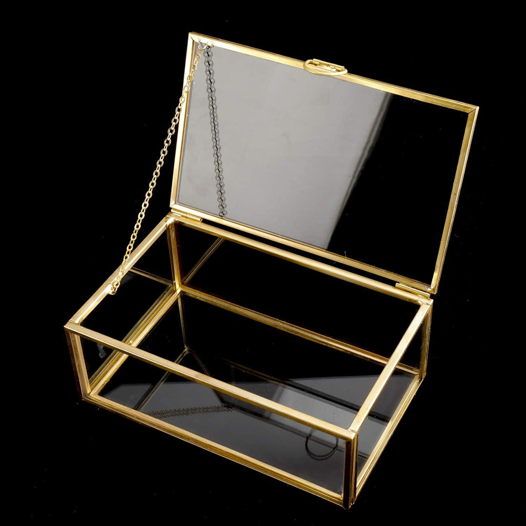 Small gold-tone glass keepsake box with its hinged lid open against a dark background.